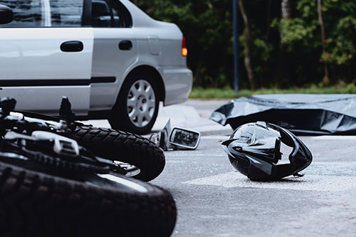 Motorcycle and helmet on the road after a collision with a car