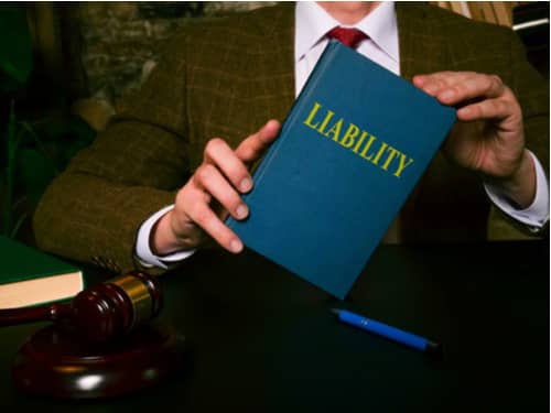 A slip and fall lawyer in Delray Beach holding a book on liability