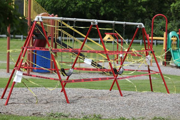 A swingset with caution tape on it