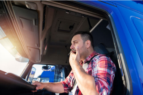 a tired truck driver yawning may need a Delray Beach Truck Accident Attorney