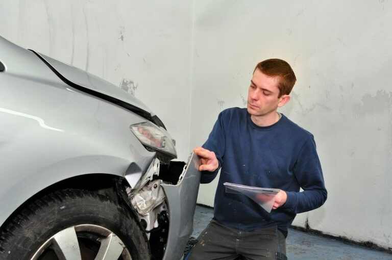 a man looking at his damaged car